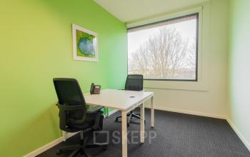 Kantoorruimte te huur op Atealaan 34A in Herentals met twee bureaustoelen, een wit bureau en een groene muurdecoratie.