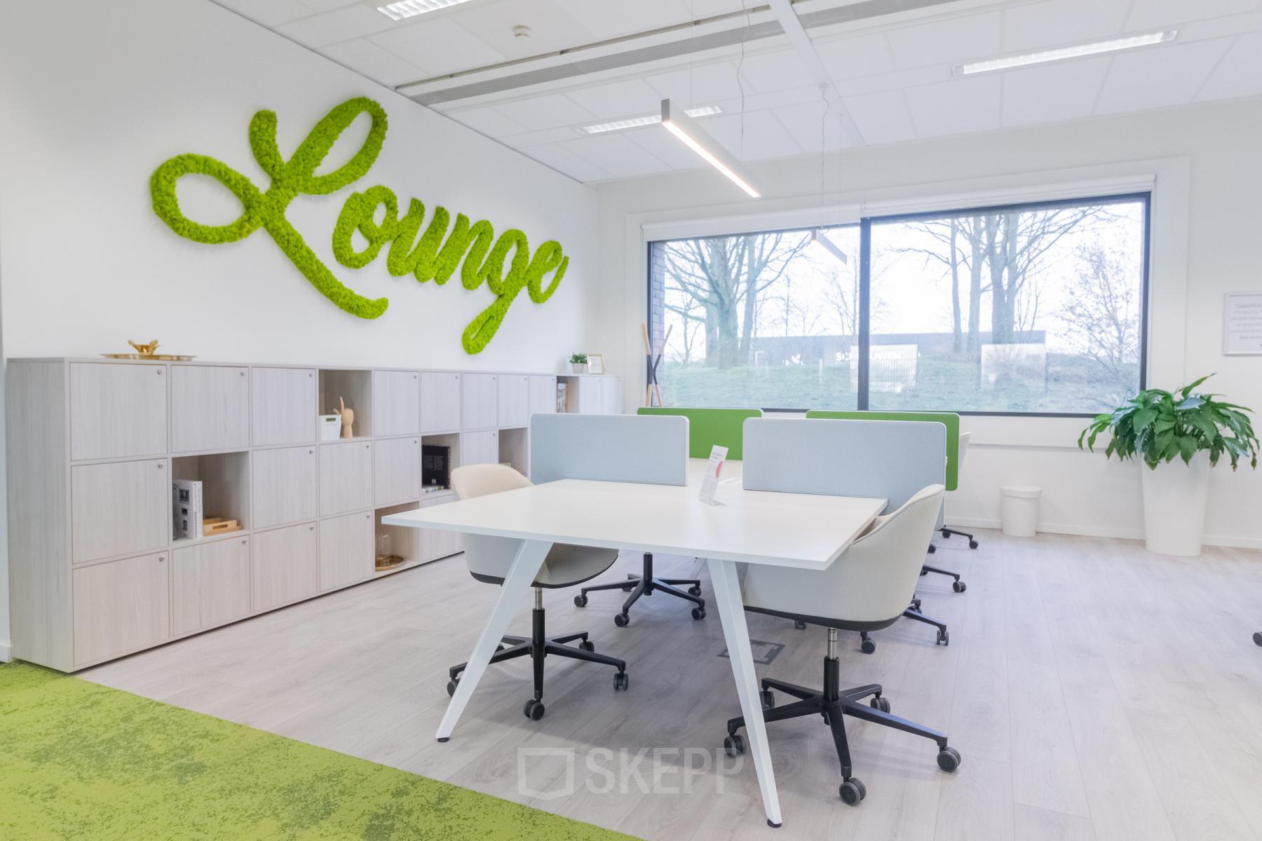 Moderne kantoorruimte te huur op Atealaan 34A, Herentals. Verfijnde werkplekken met ergonomische stoelen en veel natuurlijk licht. Planten en een muurschildering 'Lounge' voegen een frisse touch toe aan de ruimte.