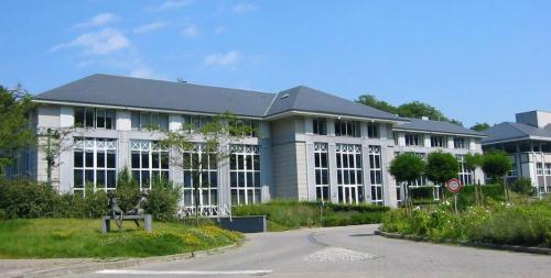 Modern kantoorgebouw te huur aan Terhulpsesteenweg 6A, Hoeilaart, met grote ramen en omgeven door groen.